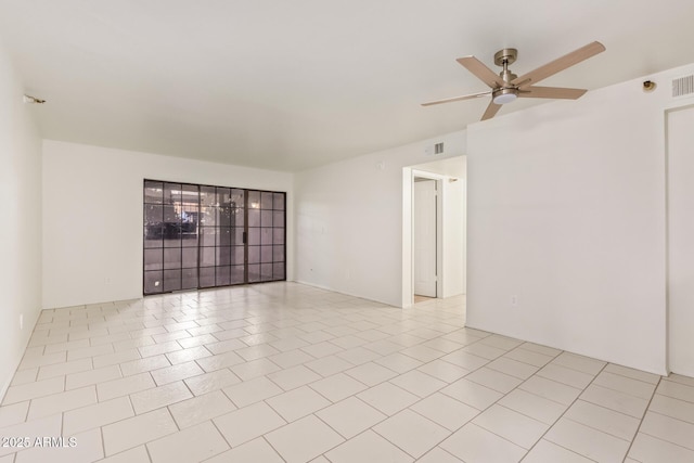 empty room featuring ceiling fan, visible vents, and tile patterned floors