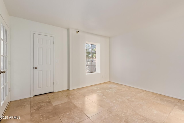 spare room with baseboards