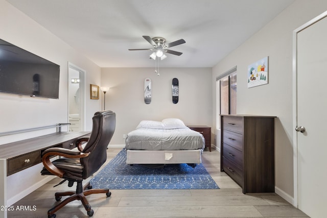 bedroom with baseboards, ceiling fan, ensuite bathroom, and light wood-style floors