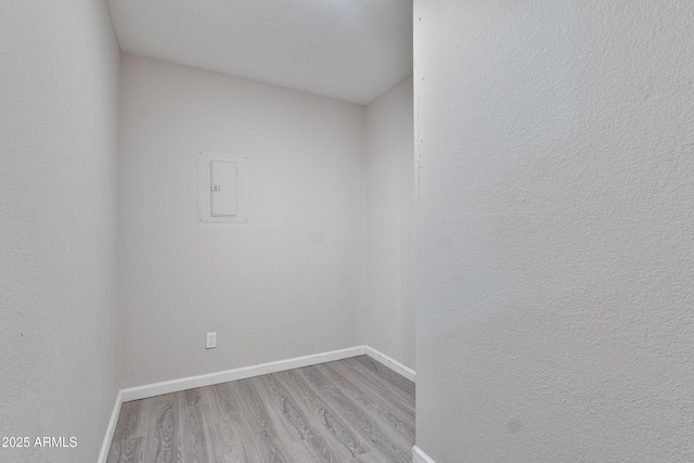 spare room with baseboards and light wood finished floors