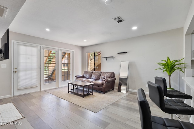 living room featuring visible vents, recessed lighting, light wood-style floors, and baseboards