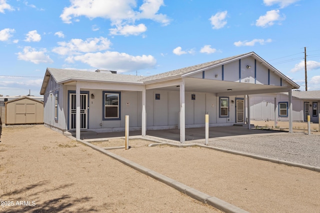 4410 S 12th Dr Unit 1-2, Phoenix, AZ 85041 - back of property featuring a carport, board and batten siding, gravel driveway, and a shingled roof