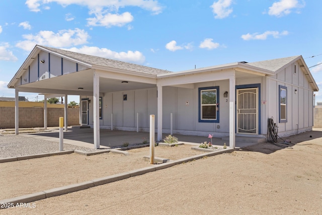 4410 S 12th Dr Unit 1-2, Phoenix, AZ 85041 - view of front facade featuring board and batten siding, a shingled roof, and an attached carport