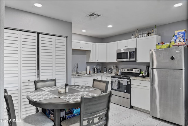 4410 S 12th Dr Unit 1-2, Phoenix, AZ 85041 - kitchen featuring appliances with stainless steel finishes, a sink, white cabinetry, recessed lighting, and light tile patterned flooring