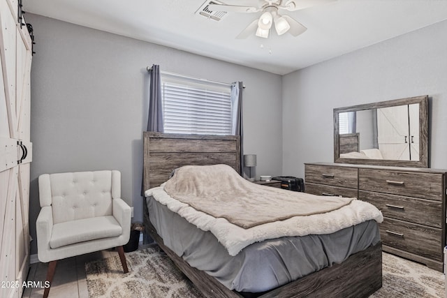 4410 S 12th Dr Unit 1-2, Phoenix, AZ 85041 - tiled bedroom with a barn door, multiple windows, and a ceiling fan