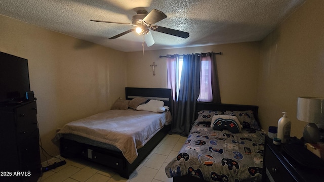 bedroom with ceiling fan, light tile patterned floors, and a textured ceiling