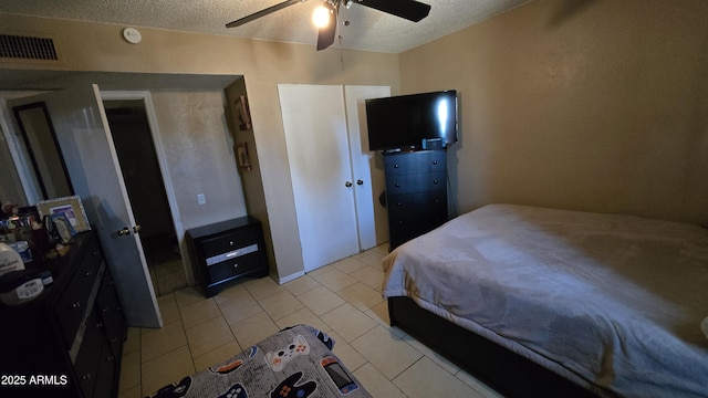 bedroom with light tile patterned flooring, ceiling fan, and a textured ceiling