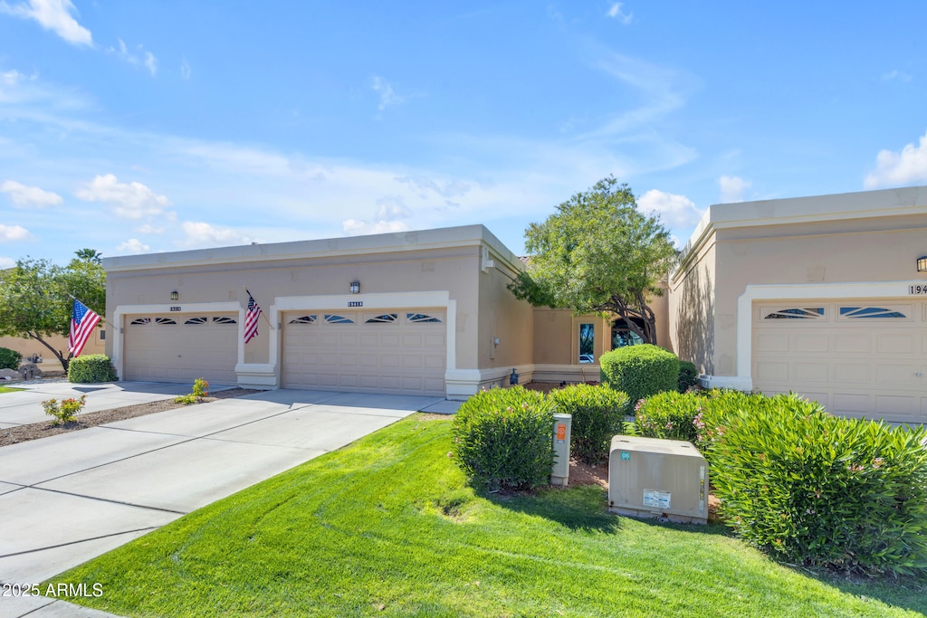 view of front facade featuring stucco siding, a front yard, a garage, and driveway