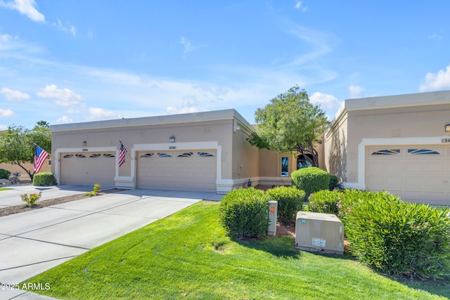 view of front facade featuring stucco siding, a front yard, a garage, and driveway