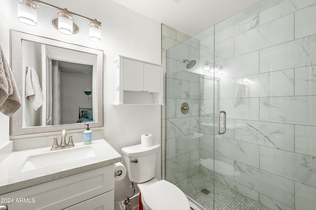 bathroom featuring vanity, an enclosed shower, and toilet