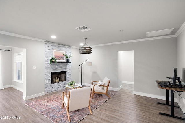 living room featuring hardwood / wood-style floors, a fireplace, and crown molding