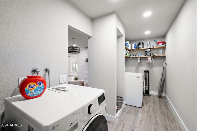 washroom featuring separate washer and dryer and light hardwood / wood-style flooring