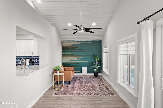 sitting room with light wood-type flooring, plenty of natural light, wooden ceiling, and ceiling fan