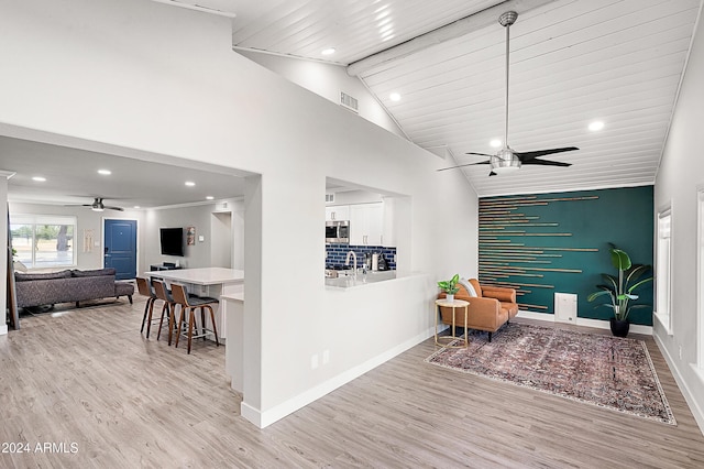 sitting room with ceiling fan, light hardwood / wood-style flooring, vaulted ceiling, and sink