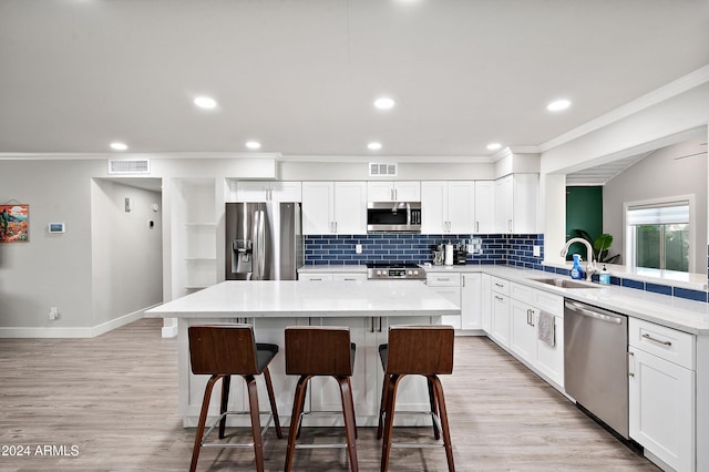 kitchen with a breakfast bar, sink, a kitchen island, and appliances with stainless steel finishes