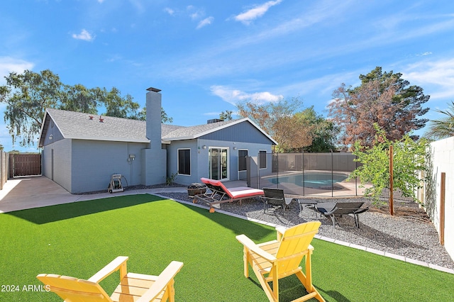 rear view of house featuring a fenced in pool and a patio area