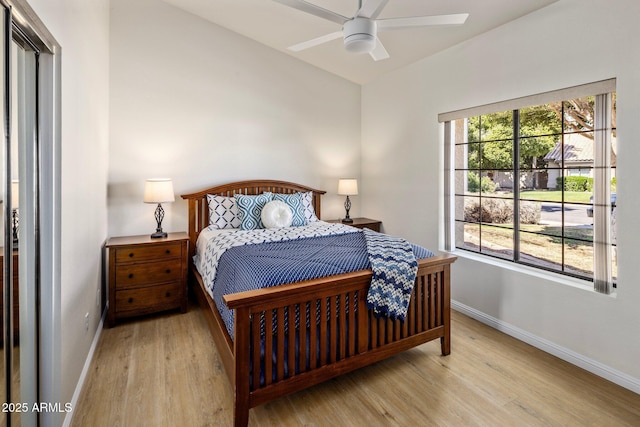 bedroom featuring multiple windows, baseboards, and wood finished floors