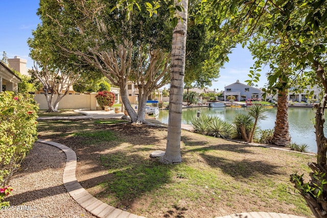 view of yard featuring a residential view, a water view, and fence