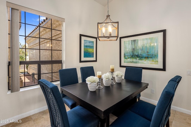 dining area featuring a chandelier, light tile patterned floors, and baseboards