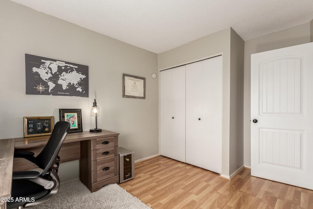 office area with light wood-style floors and baseboards