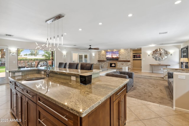 401 E Braeburn Dr, Phoenix, AZ 85022 - kitchen featuring a sink, light tile patterned floors, light colored carpet, a center island with sink, and a ceiling fan