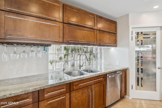 401 E Braeburn Dr, Phoenix, AZ 85022 - kitchen with stainless steel dishwasher, a sink, light tile patterned flooring, brown cabinetry, and light stone countertops