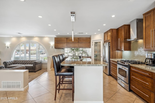 401 E Braeburn Dr, Phoenix, AZ 85022 - kitchen featuring wall chimney exhaust hood, appliances with stainless steel finishes, a kitchen breakfast bar, light stone counters, and tasteful backsplash