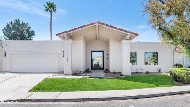 view of front facade with driveway, a front yard, an attached garage, and stucco siding