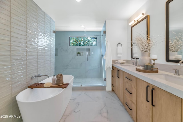 full bathroom with marble finish floor, a soaking tub, a sink, and a shower stall