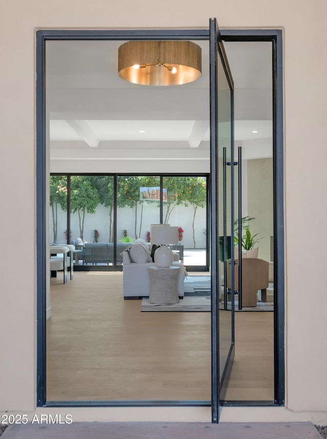 entryway with wood finished floors and beam ceiling