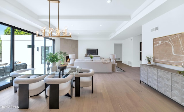 dining area with beam ceiling, an inviting chandelier, visible vents, and light wood-style floors