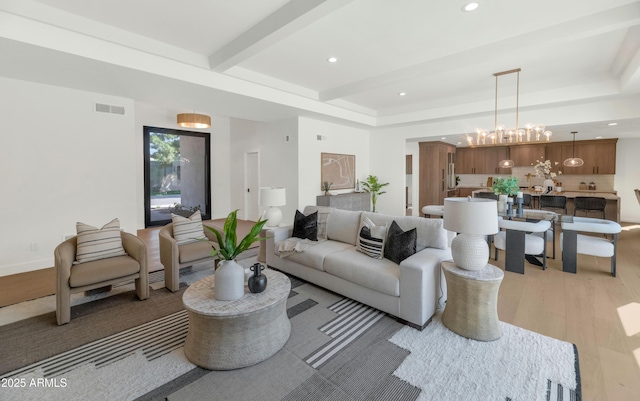 living room featuring a notable chandelier, recessed lighting, visible vents, light wood-type flooring, and beam ceiling