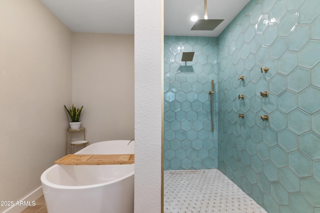 bathroom with a freestanding bath, tiled shower, baseboards, and tile patterned floors