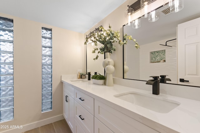 bathroom featuring double vanity, walk in shower, a sink, and wood finished floors