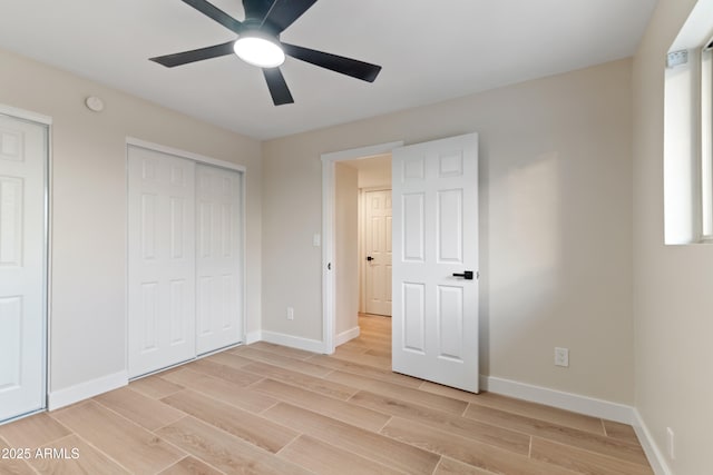 unfurnished bedroom with a ceiling fan, baseboards, two closets, and wood finish floors