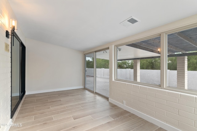 spare room with baseboards, visible vents, and wood tiled floor