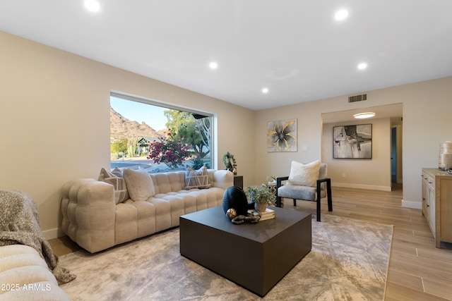 living area with recessed lighting, visible vents, baseboards, and wood finish floors
