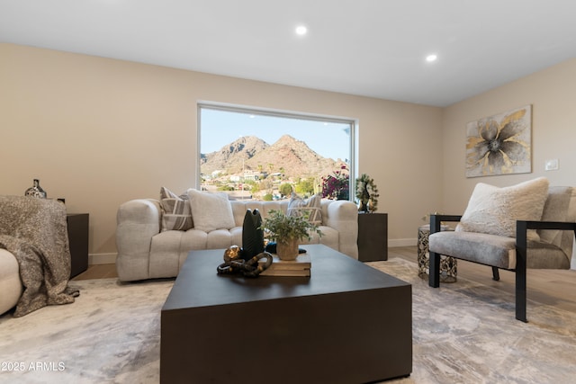 living area with recessed lighting, a mountain view, and baseboards