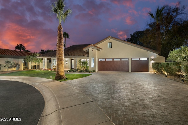 mediterranean / spanish-style house with a garage and a lawn