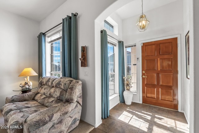 foyer entrance featuring a chandelier and dark tile patterned flooring