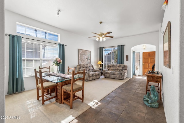 tiled dining space featuring a healthy amount of sunlight and ceiling fan