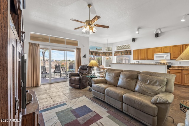 living room with a textured ceiling and ceiling fan