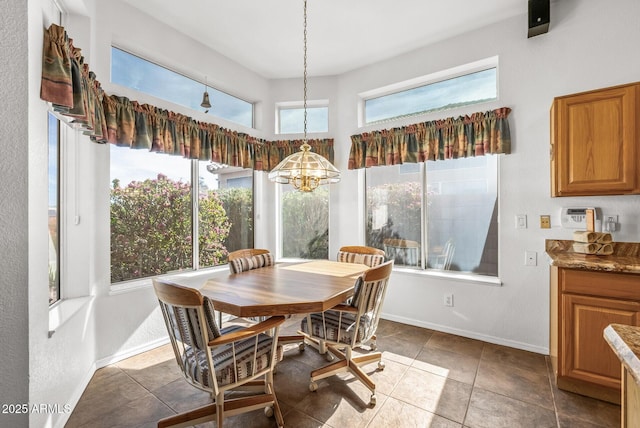 dining area with dark tile patterned flooring and a wealth of natural light