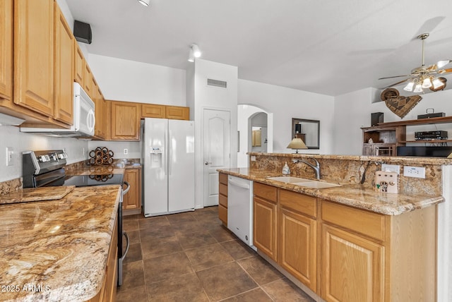 kitchen featuring sink, white appliances, ceiling fan, a kitchen island with sink, and light stone counters