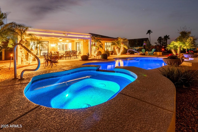 view of swimming pool featuring a pool with connected hot tub, a patio area, and a ceiling fan