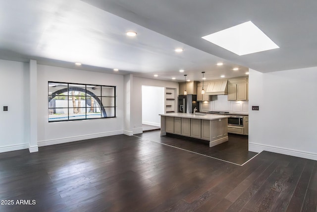 3646 W Brown St, Phoenix, AZ 85051 - kitchen featuring black refrigerator with ice dispenser, light countertops, dark wood-style flooring, a center island with sink, and a skylight