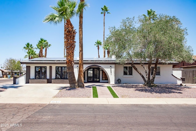 3646 W Brown St, Phoenix, AZ 85051 - view of front facade with french doors, solar panels, and stucco siding