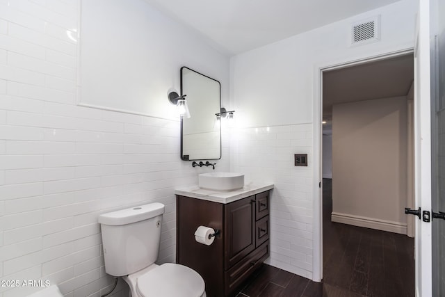 3646 W Brown St, Phoenix, AZ 85051 - bathroom with tile walls, vanity, wood finished floors, and toilet