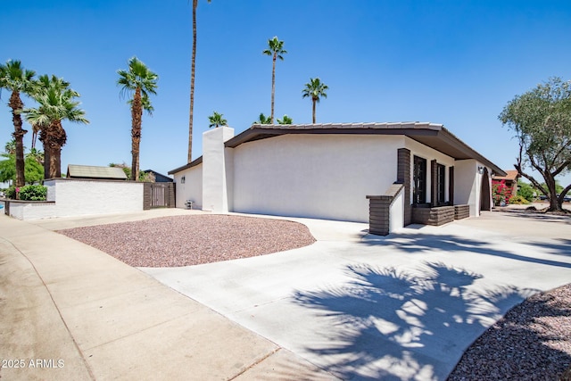 3646 W Brown St, Phoenix, AZ 85051 - view of front of home featuring concrete driveway, stucco siding, and a chimney