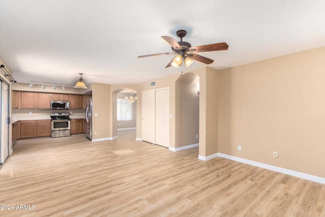 unfurnished living room featuring light hardwood / wood-style flooring, ceiling fan, and track lighting